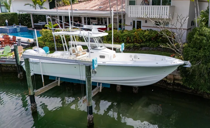Slide: The Image of 2019 Edgewater 320CC boat docked near waterfront home. - 8
