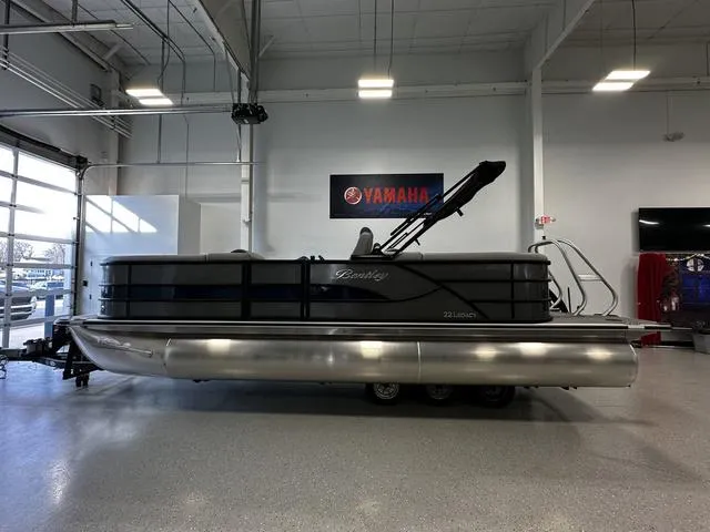 Slide: The Image of 2025 Bentley Pontoons 223 NAVIGATOR in showroom, side view, Yamaha sign in background. - 2
