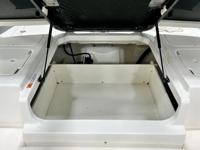 Slide: The Image of 2024 Chaparral 19 SSi OB boat storage compartment with open lid. - 10
