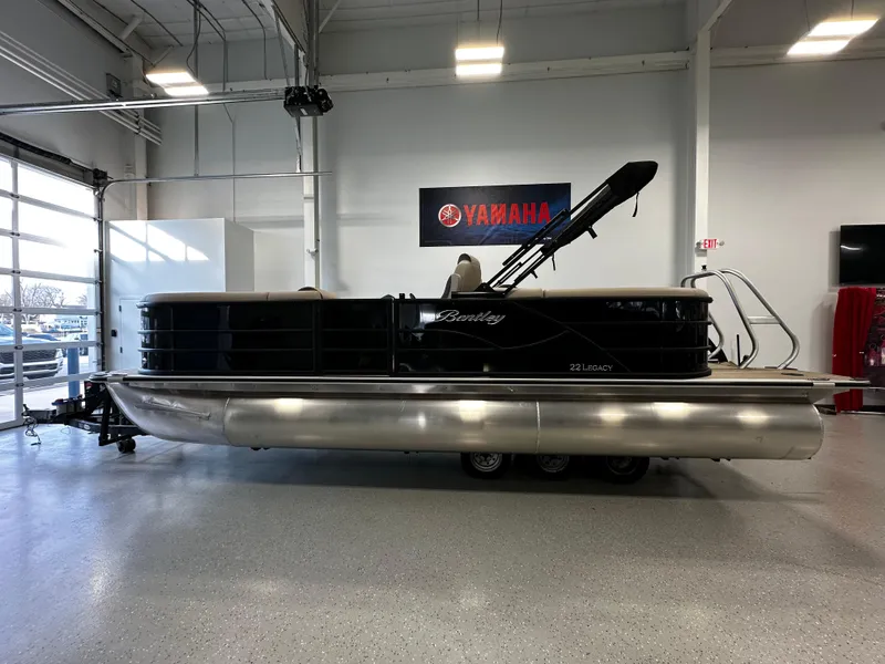 Slide: The Image of 2025 Bentley Pontoons 223 NAVIGATOR in showroom, side view, with Yamaha signage. - 2