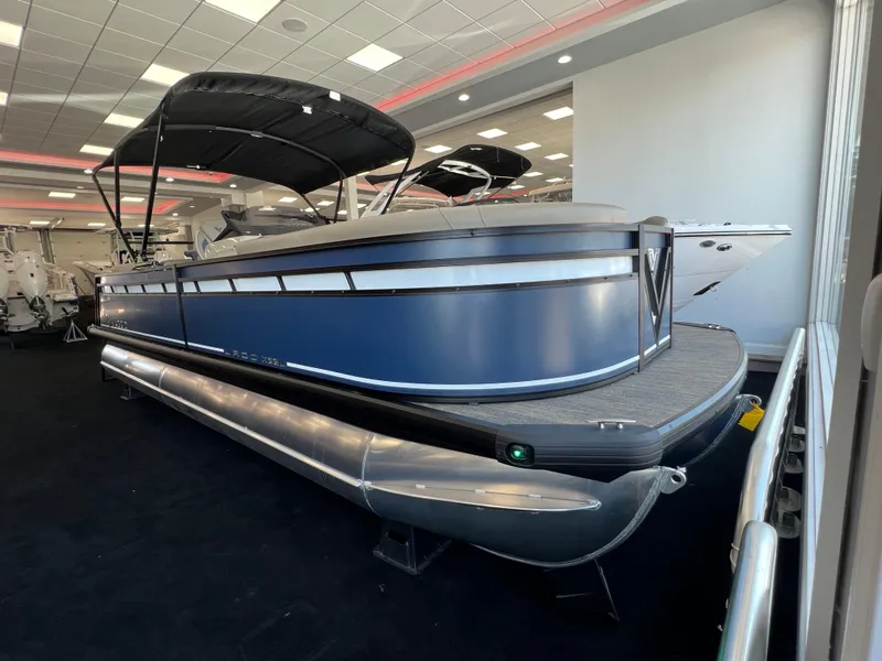 The Image of 2025 Viaggio Lago X-U pontoon boat displayed indoors, featuring sleek blue design and canopy. - 0