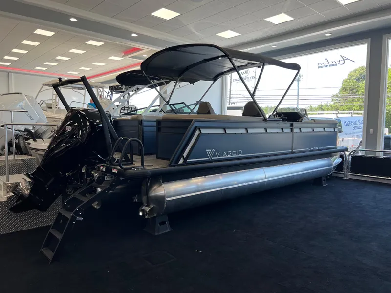 Slide: The Image of 2025 Viaggio Lago X-U pontoon boat displayed indoors with sleek design and canopy. - 1