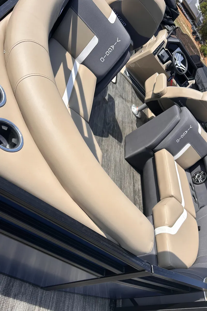 Slide: The Image of 2025 Viaggio Lago X-U boat interior with beige and gray seating, cup holders, and steering wheel. - 8