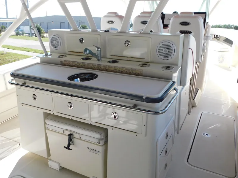 Slide: The Image of 2013 Hydra-Sports 4200 Siesta boat interior with sink, storage, and seating area. - 13