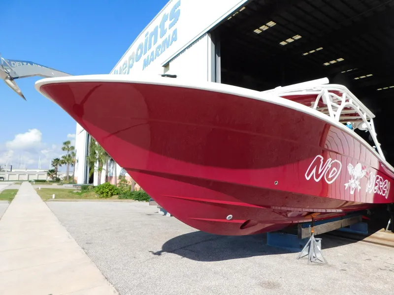 Slide: The Image of 2013 Hydra-Sports 4200 Siesta boat in red, parked outside a marina. - 3