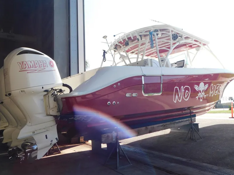 Slide: The Image of 2013 Hydra-Sports 4200 Siesta boat with Yamaha engines, red hull, docked indoors. - 4