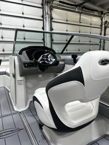Slide: The Image of 2024 Chaparral 21 SSI Sport boat interior with steering wheel and white seating. - 9