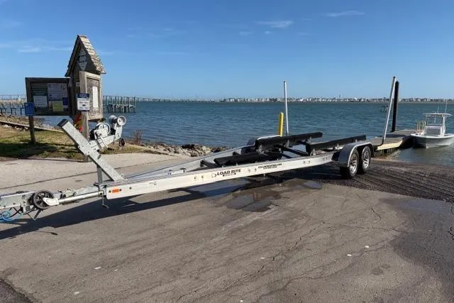 Slide: The Image of Trailer for 2019 Sportsman Masters 267 Bay Boat at a boat ramp by the water. - 16