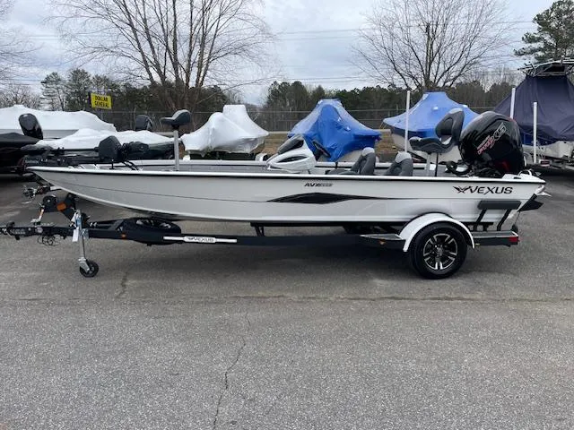 Slide: The Image of 2025 Vexus AVX V2 1880 boat on trailer, parked outdoors. - 2