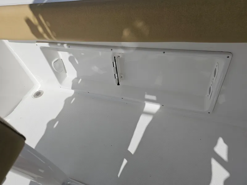 Slide: The Image of Interior view of 2025 Savannah 2200 Offshore boat, featuring white and beige seating area. - 25