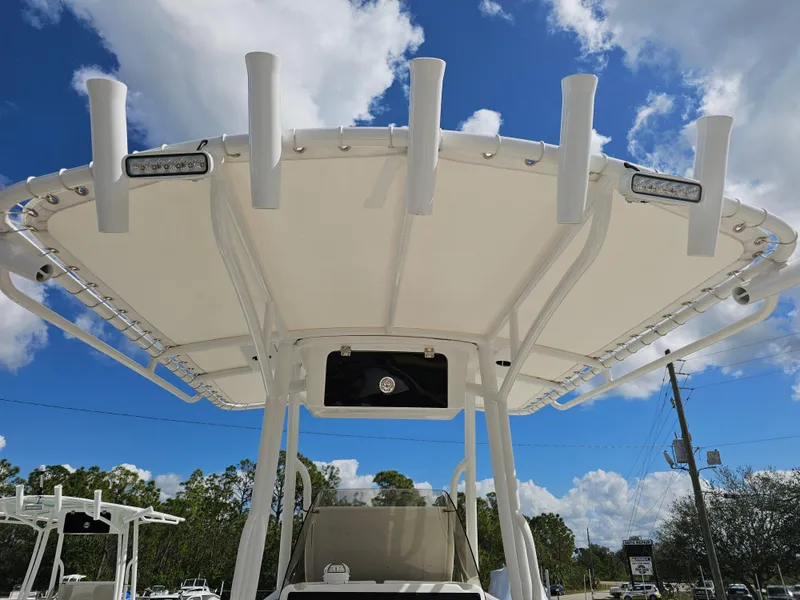 Slide: The Image of 2025 Savannah 2200 Offshore boat with T-top and rod holders under a blue sky. - 28