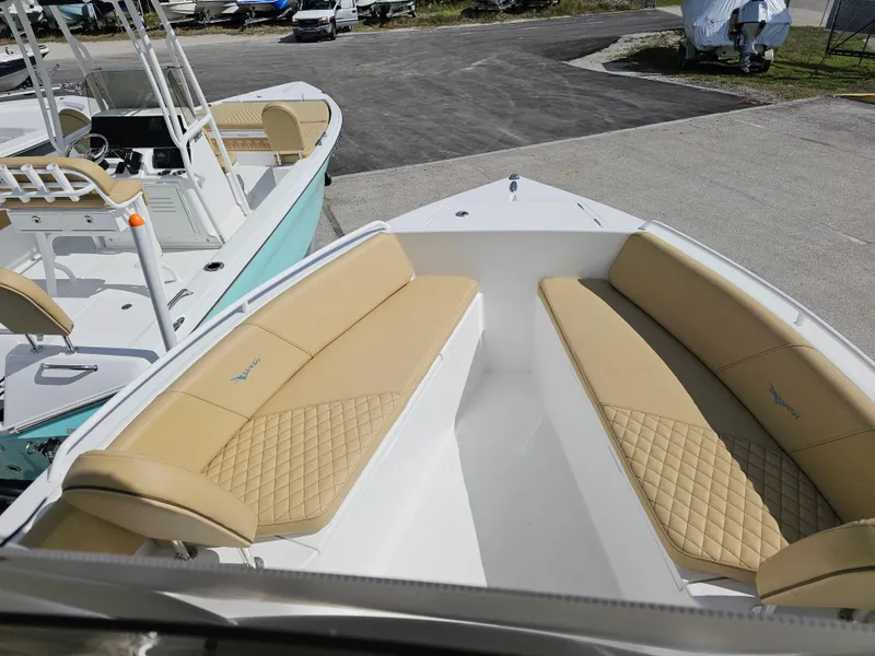 Slide: The Image of 2025 Savannah 2200 Offshore boat with tan cushioned seating, docked on a sunny day. - 30