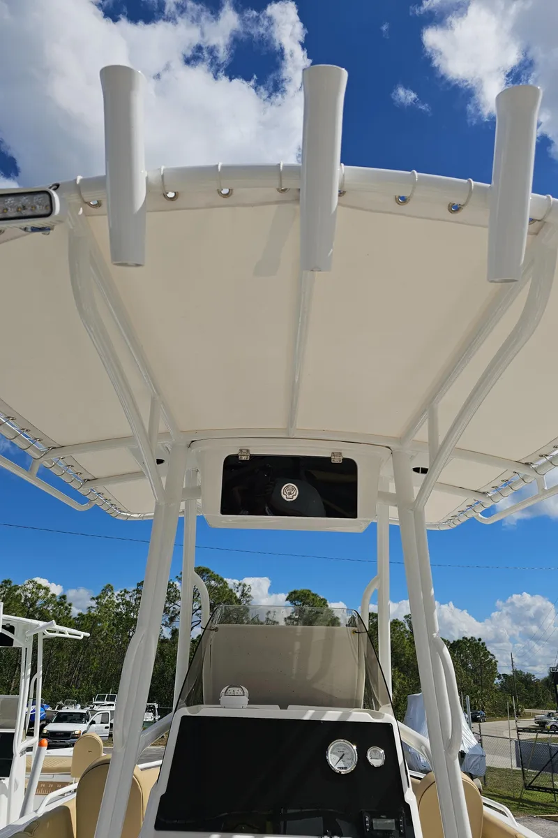 Slide: The Image of 2025 Savannah 2200 Offshore boat with T-top and rod holders under a clear blue sky. - 43