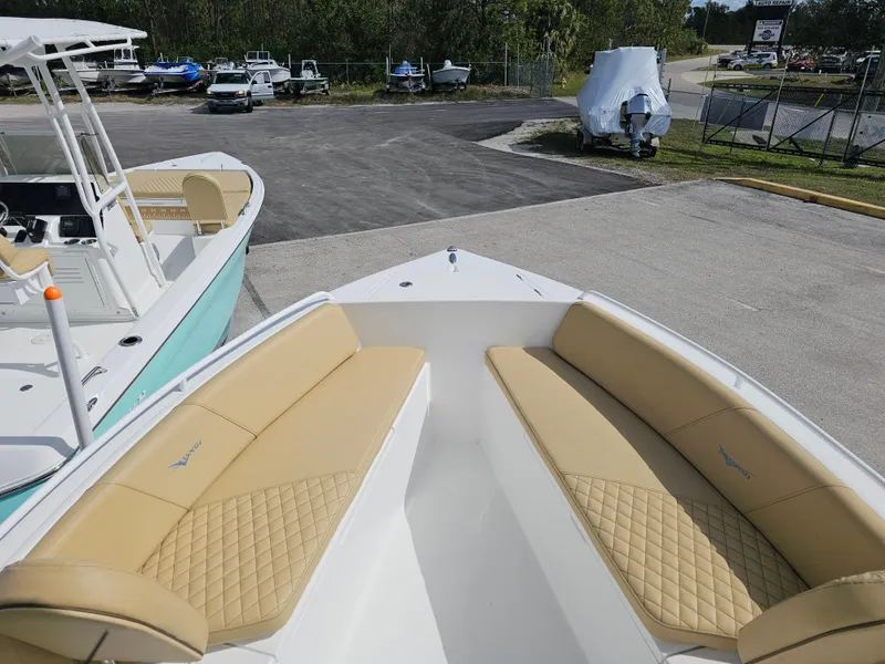 Slide: The Image of 2025 Savannah 2200 Offshore boat with tan seating, parked in a marina. - 6