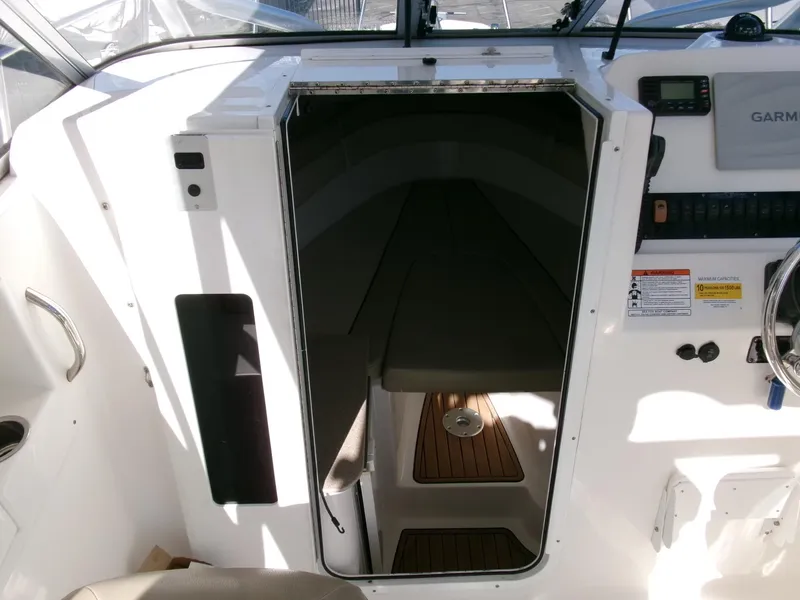 Slide: The Image of 2016 Sea Fox 256 Voyager cabin entrance with wooden flooring and control panel. - 10