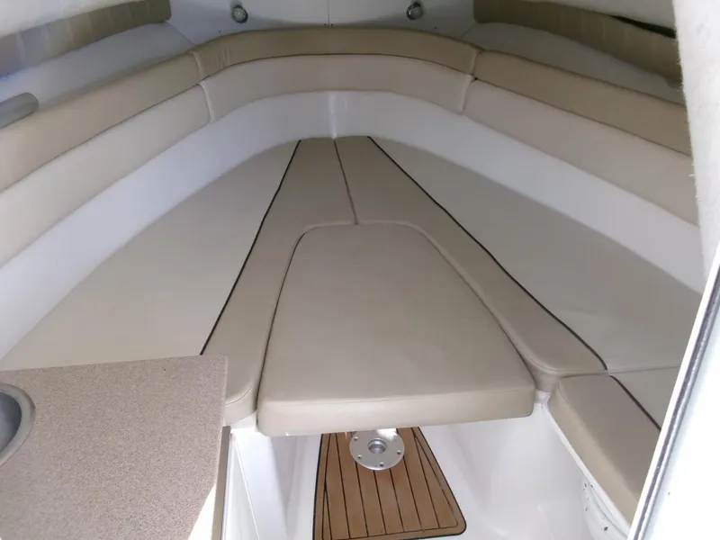 Slide: The Image of 2016 Sea Fox 256 Voyager cabin interior with beige seating and wooden flooring. - 11
