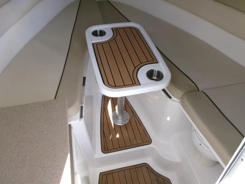 Slide: The Image of 2016 Sea Fox 256 Voyager interior with wood-accented table and seating area. - 12