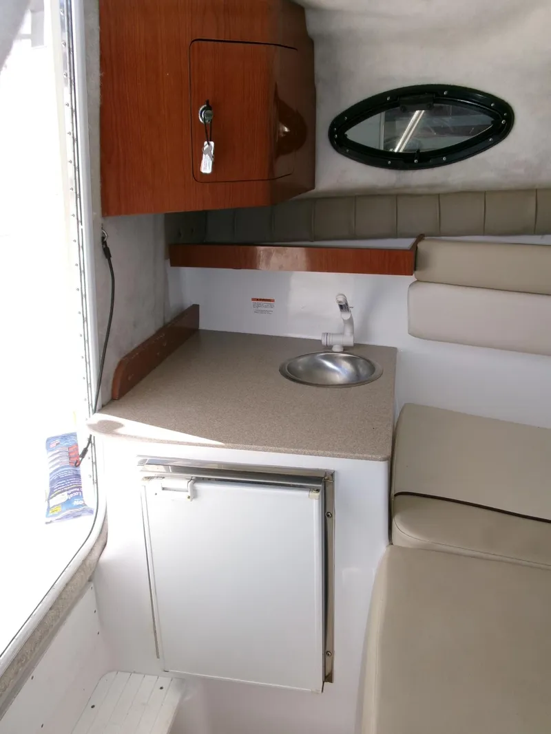 Slide: The Image of 2016 Sea Fox 256 Voyager cabin interior with kitchenette, sink, and seating. - 13