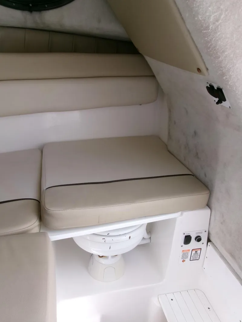 Slide: The Image of 2016 Sea Fox 256 Voyager cabin interior with cushioned seating and marine toilet. - 14