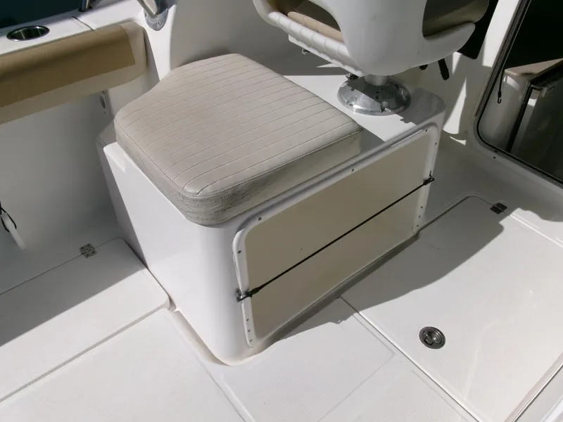 Slide: The Image of 2016 Sea Fox 256 Voyager boat seating area with storage compartment. - 21