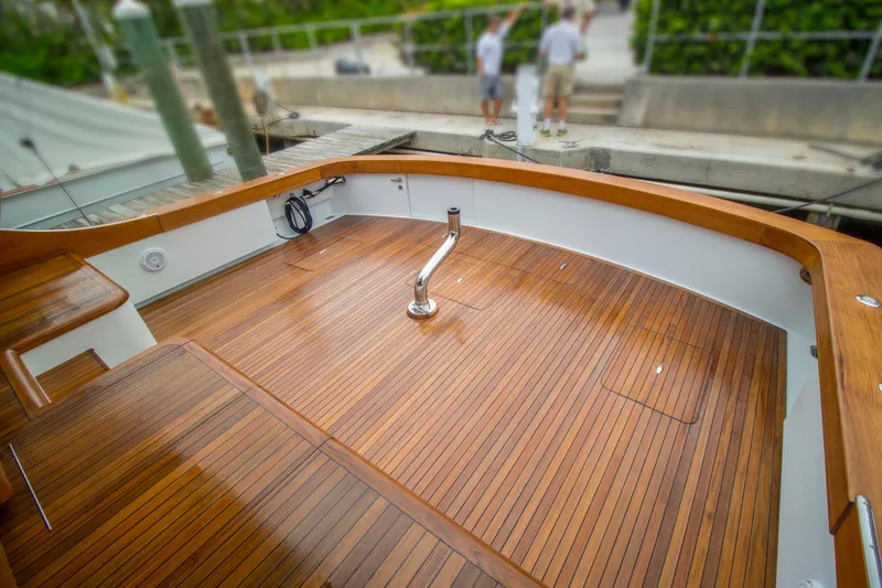 Slide: The Image of Teak deck of 2000 Merritt 80' Sportfish boat, docked with polished wood finish. - 11