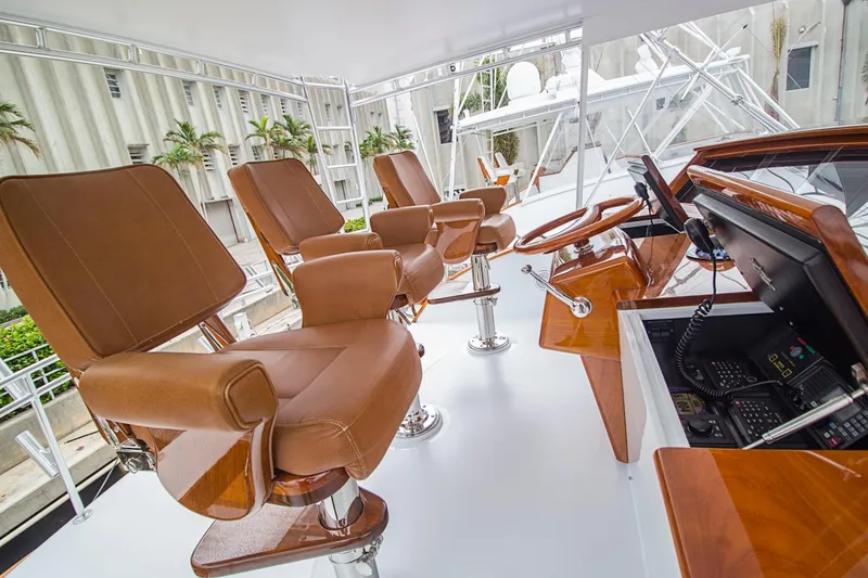 Slide: The Image of Luxurious helm seating on a 2000 Merritt 80' Sportfish yacht, featuring leather chairs and polished wood accents. - 17