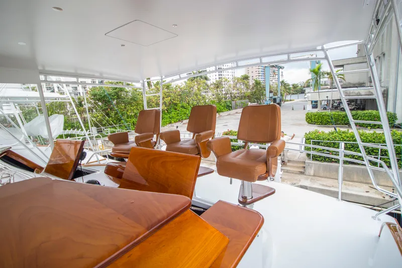 Slide: The Image of Luxurious seating on 2000 Merritt 80' Sportfish yacht deck, featuring elegant wooden chairs. - 19