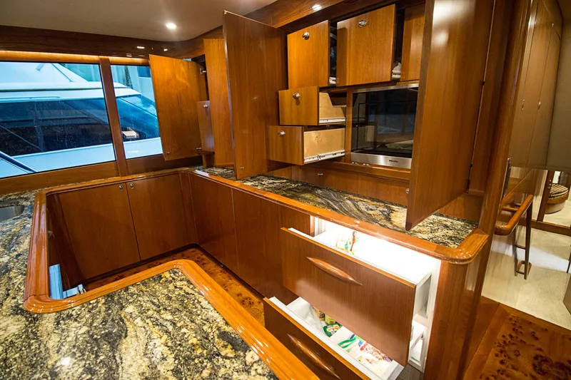 Slide: The Image of Luxurious kitchen interior of 2000 Merritt 80' Sportfish yacht with wooden cabinetry and granite countertops. - 34