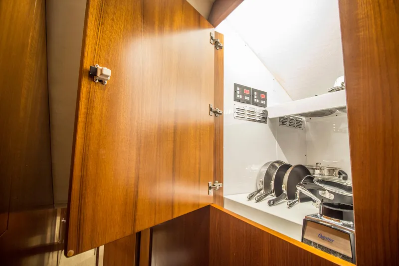 Slide: The Image of Open wooden cabinet with cookware inside Merritt 80' Sportfish yacht, 2000 model. - 36