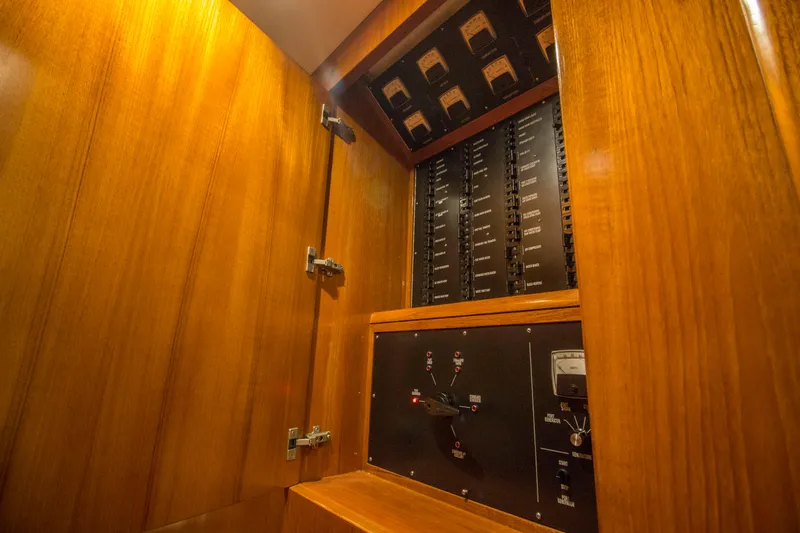 Slide: The Image of Electrical panel inside 2000 Merritt 80' Sportfish yacht, featuring wooden cabinetry. - 38