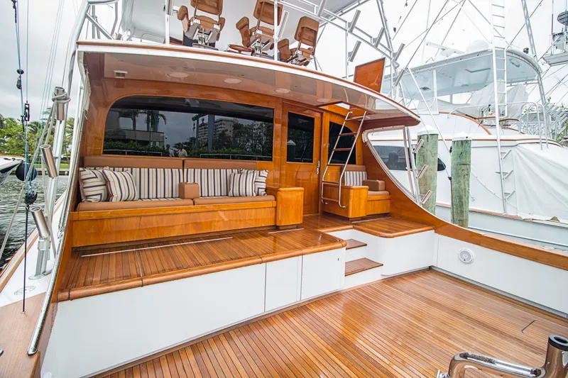 Slide: The Image of Luxurious 2000 Merritt 80' Sportfish yacht with elegant wooden deck and seating area. - 4