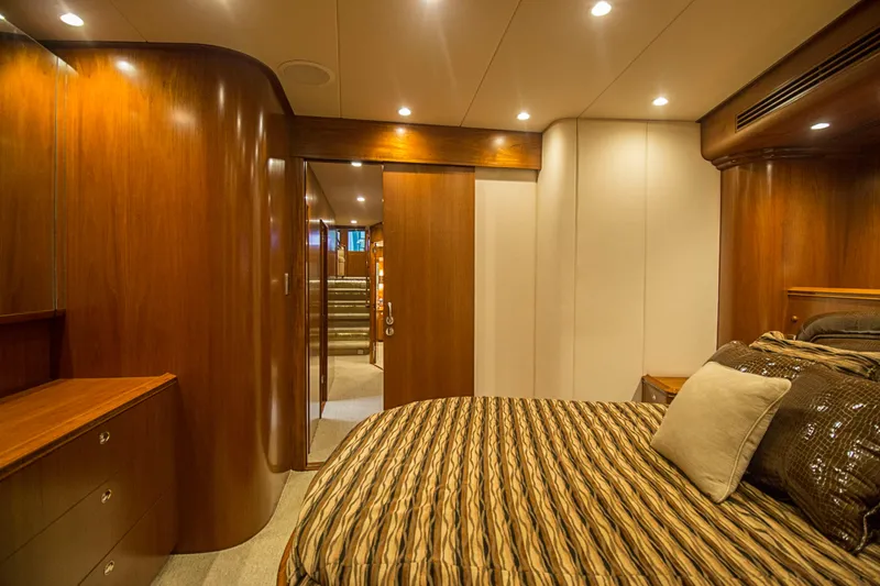 Slide: The Image of Luxurious bedroom interior on a 2000 Merritt 80' Sportfish yacht with wood paneling. - 48