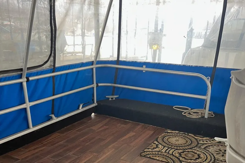 Slide: The Image of 1986 Waterhouse 14 X 44 houseboat interior with wooden flooring and blue railing. - 2