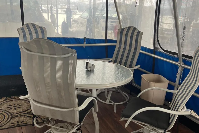 Slide: The Image of 1986 Waterhouse 14 X 44 Houseboat interior with patio furniture and glass table. - 3