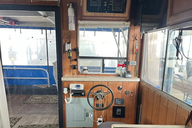 Slide: The Image of 1986 Waterhouse 14 X 44 houseboat interior with wooden helm, steering wheel, and navigation equipment. - 4