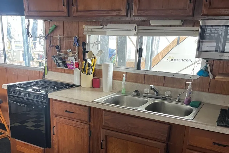 Slide: The Image of 1986 Waterhouse 14 X 44 Houseboat kitchen with wooden cabinets, stove, and double sink. - 7