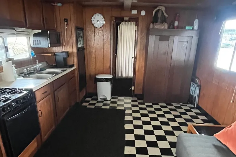 Slide: The Image of 1986 Waterhouse 14 X 44 houseboat interior with wood paneling and checkered flooring. - 8