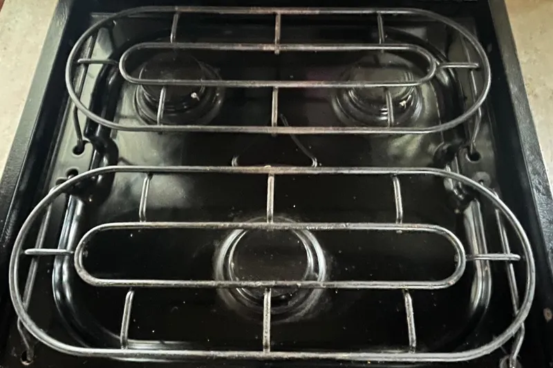 Slide: The Image of Stovetop on 1986 Waterhouse 14 X 44 Houseboat, featuring dual burners and metal grates. - 9