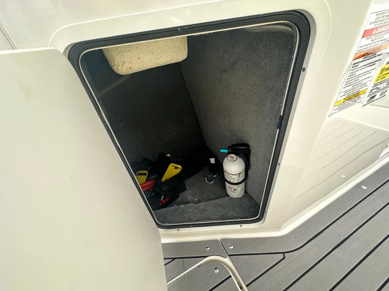 Slide: The Image of Storage compartment of 2021 Sea Ray SPX 190 OB boat with safety equipment. - 12