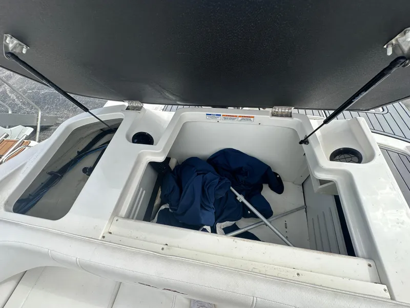 Slide: The Image of Open storage compartment on 2021 Sea Ray SPX 190 OB boat, containing blue fabric and equipment. - 15