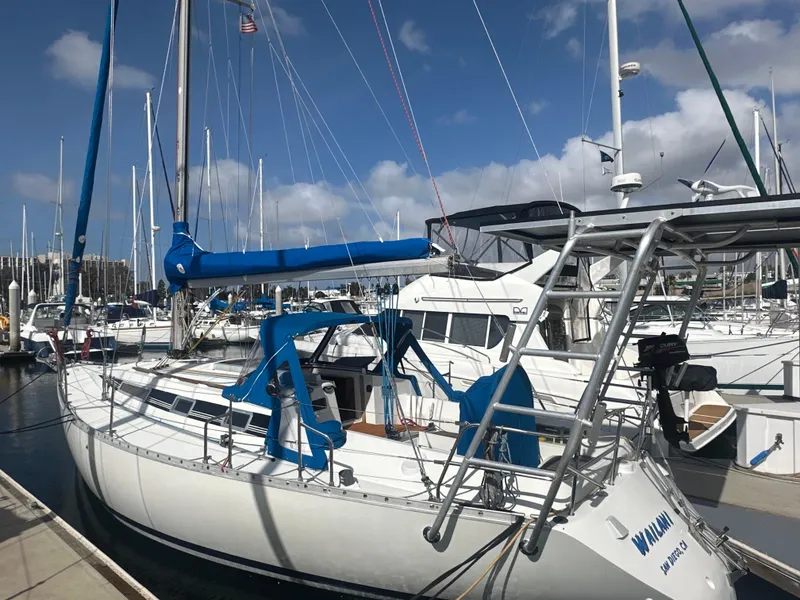 Slide: The Image of 1986 Beneteau First 375 sailboat docked at marina under blue sky. - 1