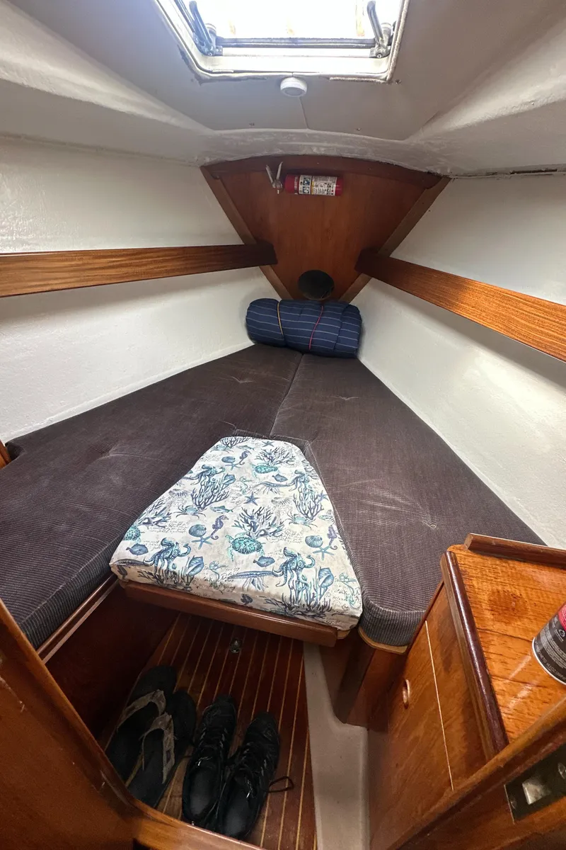 Slide: The Image of Cozy cabin interior of 1986 Beneteau First 375 sailboat with wooden accents and bedding. - 17