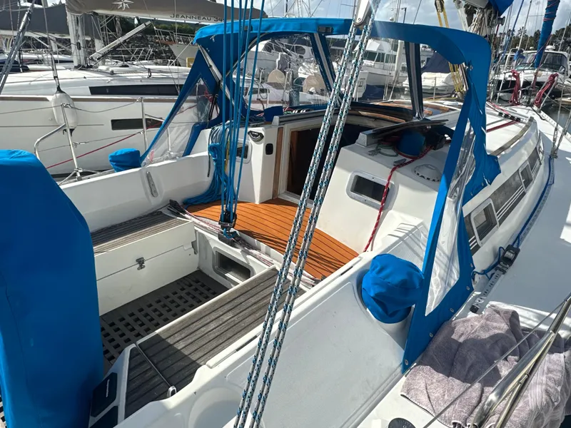 Slide: The Image of 1986 Beneteau First 375 sailboat with blue accents, docked in a marina. - 2
