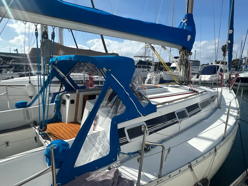 Slide: The Image of 1986 Beneteau First 375 sailboat docked, featuring blue canvas covers and sleek design. - 3