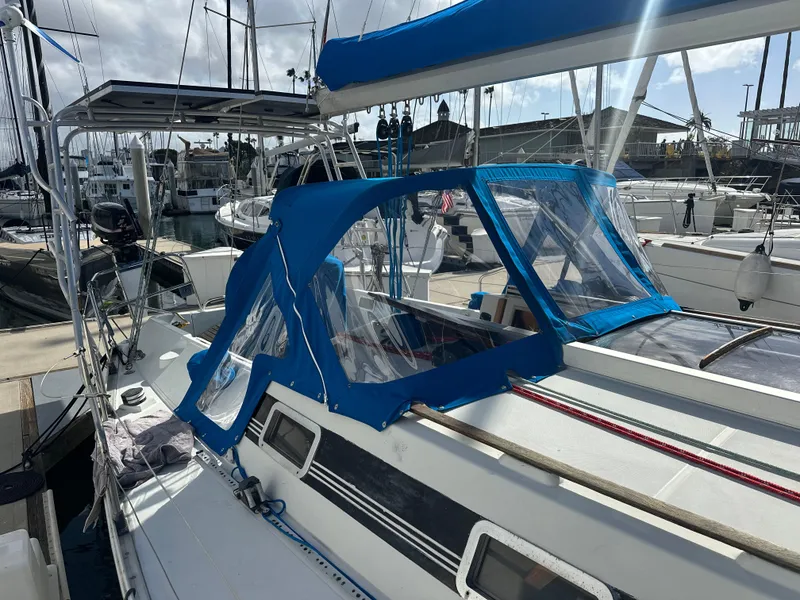 Slide: The Image of 1986 Beneteau First 375 sailboat with blue canopy docked at marina. - 7