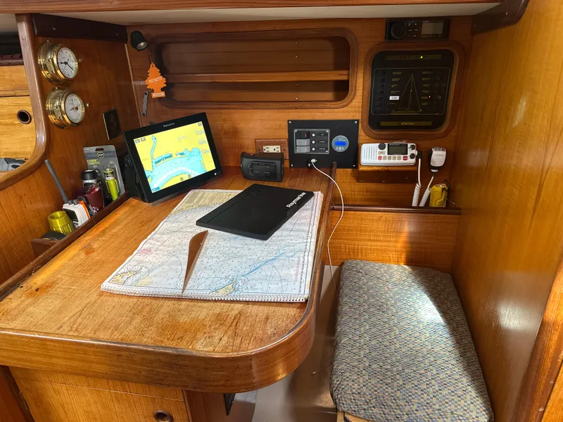 Slide: The Image of Navigation station inside 1986 Beneteau First 375 sailboat with charts and electronic equipment. - 9