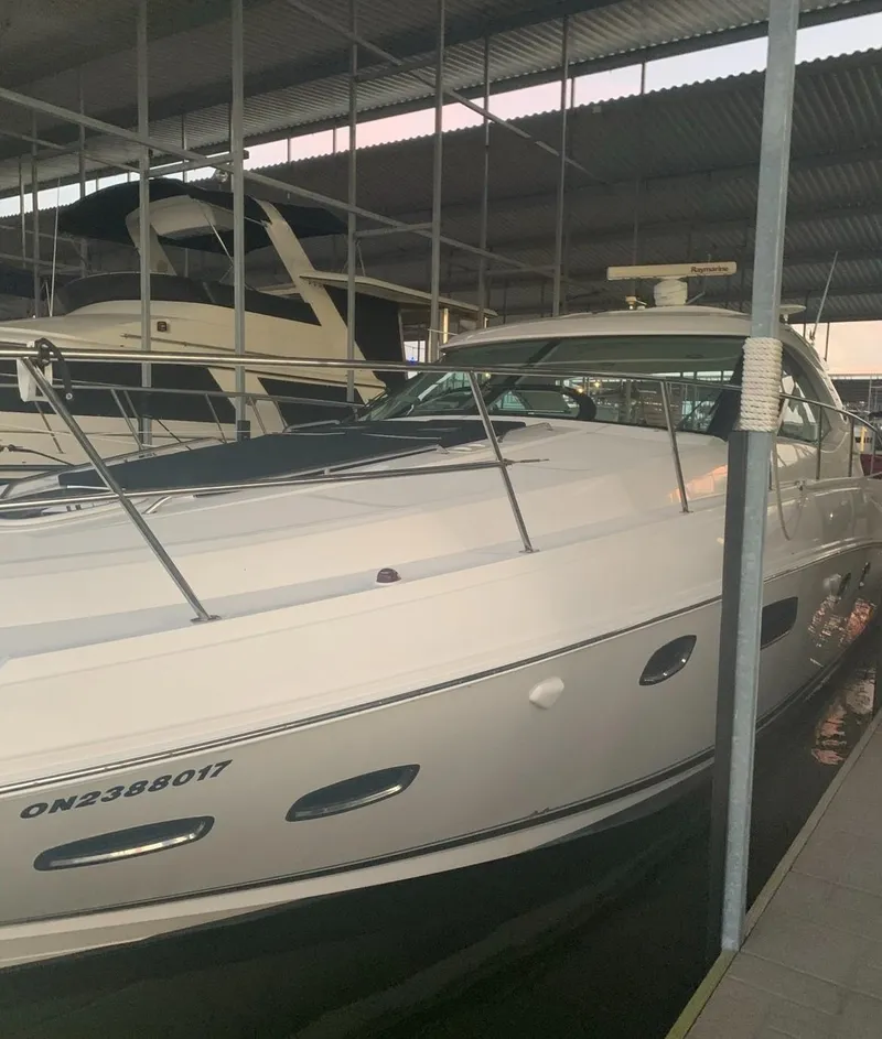 Slide: The Image of 2009 Sea Ray 470 Sundancer yacht docked in a marina under a metal roof. - 8
