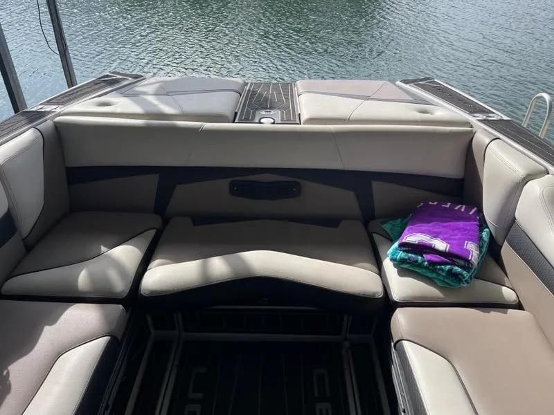 Slide: The Image of 2019 Centurion Fi25 boat interior with seating and towels by the water. - 20