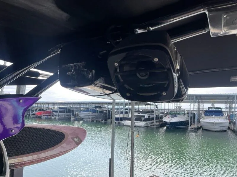 Slide: The Image of 2019 Centurion Fi25 boat with speaker system, docked near other boats. - 25