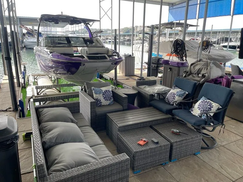 Slide: The Image of 2019 Centurion Fi25 boat docked near outdoor patio furniture set by the water. - 3